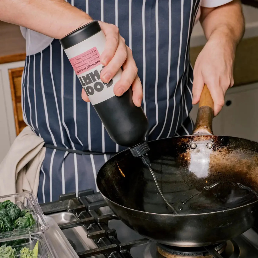 Good Phats Spanish Light Avocado Oil in a squeeze bottle poured into a wok for cooking